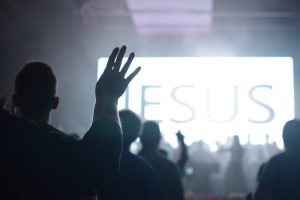 silhouette of people raising hands